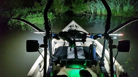 Boat on river with lights on at night