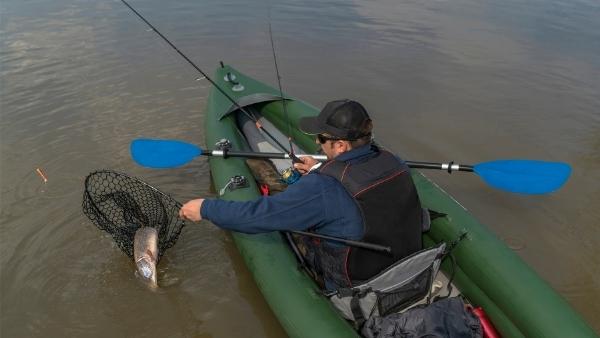 Fisherman caught pike fish on inflatable boat