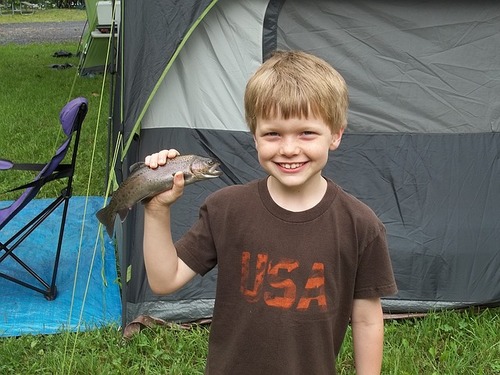 Kid smiling while holding caught fish