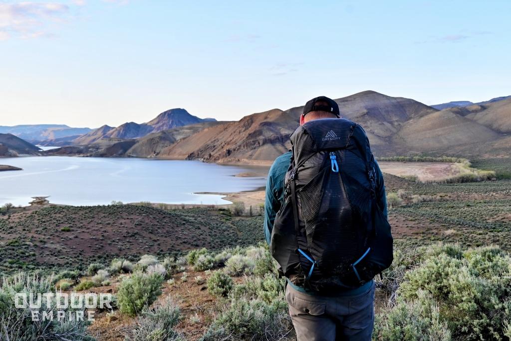 hiker carrying Gregory Focal overlooking reservoir
