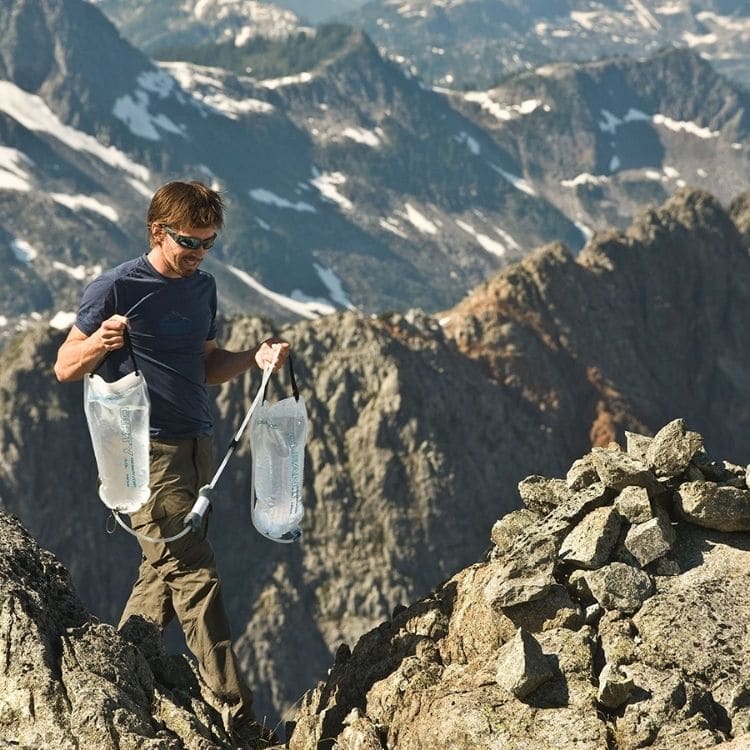 hiker carrying Platypus water reservoir on rocky mountain