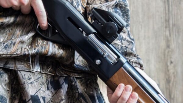 hunter holding shotgun with optic e1655125299687