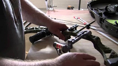 Man assembling bowfishing bow on table