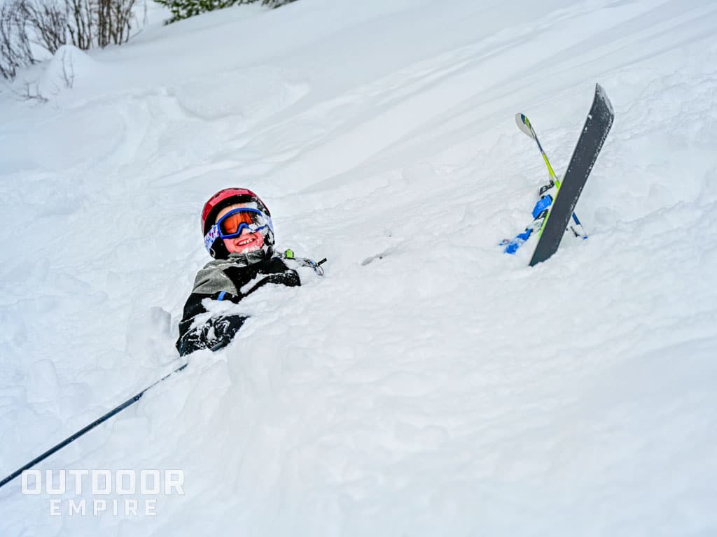 Kid skiing with motorola clipped to jacket in snow