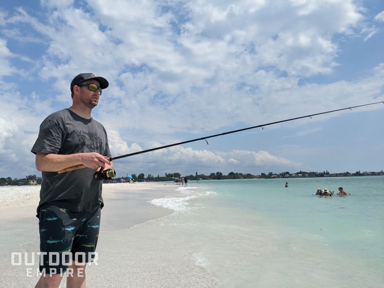 Man standing in surf on beach fishing