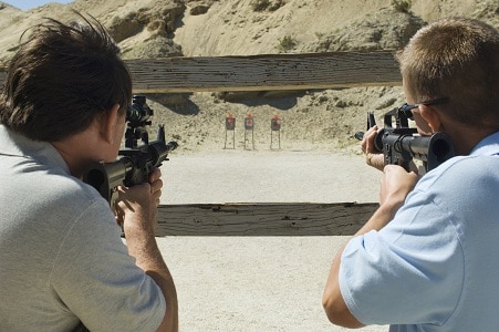 Two men aiming rifles at firing range